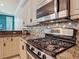 Modern kitchen featuring a stainless steel stove, custom cabinets, and granite countertops at 600 Garden Club Dr, Deland, FL 32724