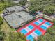 A bird's eye view of tennis and pickleball courts surrounded by trees, showcasing community recreation at 600 Garden Club Dr, Deland, FL 32724