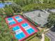 Aerial view featuring pickleball and tennis courts, complemented by lush greenery and a nearby pond at 600 Garden Club Dr, Deland, FL 32724