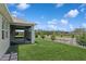 Lush green backyard with a view of the screened-in lanai, trees, and fence at 6139 Claystone Way, Mount Dora, FL 32757