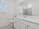 Bright bathroom with white vanity, quartz countertops, and tiled shower at 6139 Claystone Way, Mount Dora, FL 32757