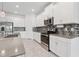 Well-lit kitchen featuring an island, stainless steel appliances, and stylish backsplash at 6139 Claystone Way, Mount Dora, FL 32757