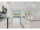 Bright kitchen with stainless steel appliances, island, and sliding door access to outdoors at 6139 Claystone Way, Mount Dora, FL 32757