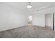 Spacious main bedroom with carpet flooring, tray ceiling, and en suite bathroom entrance at 6139 Claystone Way, Mount Dora, FL 32757