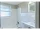 Bright bathroom with white tile, window, shower, sink, and toilet at 6203 Candlewood Ln, Orlando, FL 32809