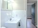 Bright bathroom featuring white tile, sink, mirror, and wood-look floors at 6203 Candlewood Ln, Orlando, FL 32809