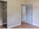 Neutral bedroom featuring wood-look floors, closet, and ensuite bathroom at 6203 Candlewood Ln, Orlando, FL 32809