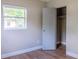 Neutral bedroom featuring wood-look floors, closet, and bright window at 6203 Candlewood Ln, Orlando, FL 32809