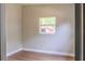 Neutral bedroom featuring wood-look floors and bright window at 6203 Candlewood Ln, Orlando, FL 32809