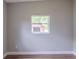 Neutral bedroom featuring wood-look floors and bright window at 6203 Candlewood Ln, Orlando, FL 32809