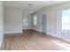 Open living room featuring hardwood floors and neutral-toned walls connecting to the dining area at 6203 Candlewood Ln, Orlando, FL 32809