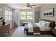 Sun-filled bedroom with two doors, a light-colored wall, ceiling fan, and a cushioned bench at 6203 Candlewood Ln, Orlando, FL 32809