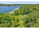 Gorgeous aerial view of lakefront property with lush green lawn, mature trees, and boathouse at 633 Balmoral Rd, Winter Park, FL 32789