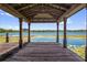 Wooden dock with gazebo overlooking lily pad filled lake at 633 Balmoral Rd, Winter Park, FL 32789