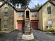Townhome with exterior stairway, private garage, manicured shrubs, and flower boxes at 6400 Raleigh St # 3015, Orlando, FL 32835