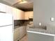 Cozy kitchen featuring white appliances, ample cabinetry, and a convenient breakfast bar area at 6400 Raleigh St # 3015, Orlando, FL 32835
