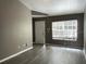 Open living room with gray walls, hard surface floors, large window and white door at 6400 Raleigh St # 3015, Orlando, FL 32835