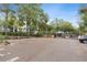 Gated community parking area with mature trees and clear parking spaces at 6400 Raleigh St # 3015, Orlando, FL 32835