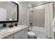 Well-lit bathroom with a white vanity, granite countertop, and bathtub with tiled shower surround at 7745 Somersworth Dr, Kissimmee, FL 34747