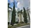 Low angle view of a light yellow and green building exterior with columns and landscaping at 7745 Somersworth Dr, Kissimmee, FL 34747