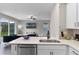 Bright kitchen with white cabinets and quartz countertops is open to the cozy living room at 7745 Somersworth Dr, Kissimmee, FL 34747