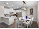 Modern kitchen with white cabinets, stainless steel appliances, and a dining area with a decorative light fixture at 7745 Somersworth Dr, Kissimmee, FL 34747