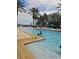 Outdoor pool featuring clear blue water, palm trees, lounge chairs, and swimmers enjoying the water at 7745 Somersworth Dr, Kissimmee, FL 34747
