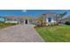Charming single-story home featuring a tile roof, arched entryway, paver driveway, and well-maintained landscaping at 8851 Fallen Oak Dr, Davenport, FL 33896