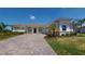 Charming single-story home featuring a tile roof, arched entryway, paver driveway, and well-maintained landscaping at 8851 Fallen Oak Dr, Davenport, FL 33896