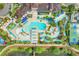Aerial view of a community pool area with slides, lounge chairs, palm trees, and a lazy river at 8989 Rhodes St, Kissimmee, FL 34747
