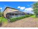 View of the backyard showcasing the screened-in lanai and landscaping at 8989 Rhodes St, Kissimmee, FL 34747