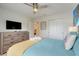 Bright bedroom with closet, TV, ensuite bath, and comfortable blue quilted bedding at 8989 Rhodes St, Kissimmee, FL 34747