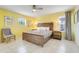 Bright bedroom featuring a ceiling fan, tiled floors, and a rustic wood bed frame at 8989 Rhodes St, Kissimmee, FL 34747