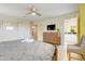 Cozy bedroom with closet, TV, ensuite bath, and comfortable grey quilted bedding at 8989 Rhodes St, Kissimmee, FL 34747