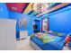 Whimsical themed bedroom with bright blue walls, colorful ceiling, and two twin beds at 8989 Rhodes St, Kissimmee, FL 34747
