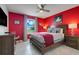 Bedroom featuring vibrant red walls, modern furniture, and ample natural light at 8989 Rhodes St, Kissimmee, FL 34747