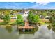 Beautiful community view featuring a scenic pier extending into the lake with clubhouse and pool in the background at 8989 Rhodes St, Kissimmee, FL 34747