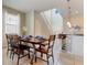 Open-concept dining area with a dining table set for six, and views of the modern kitchen at 8989 Rhodes St, Kissimmee, FL 34747
