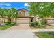 Charming home featuring a two-car garage, lush landscaping, and a brick driveway at 8989 Rhodes St, Kissimmee, FL 34747