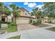 Attractive home featuring a two-car garage, brick driveway, and meticulously maintained landscaping at 8989 Rhodes St, Kissimmee, FL 34747