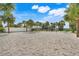 Outdoor sand volleyball court bordered by mature palm trees, perfect for community recreation and outdoor activities at 8989 Rhodes St, Kissimmee, FL 34747