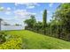 Spacious backyard with lush green lawn, black metal fence, white vinyl fence, and mature trees and bushes at 14189 Larkspur Lake Dr, Winter Garden, FL 34787