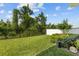 Well-manicured backyard with lush green lawn, black metal fence, white vinyl fence, and mature trees and bushes at 14189 Larkspur Lake Dr, Winter Garden, FL 34787