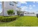 Expansive backyard featuring lush green grass, manicured landscaping, and a covered patio with an outdoor seating area at 14189 Larkspur Lake Dr, Winter Garden, FL 34787