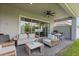 Stylish covered patio featuring comfortable seating, a ceiling fan, and sliding glass doors to blend indoor and outdoor living at 14189 Larkspur Lake Dr, Winter Garden, FL 34787