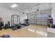 Spacious garage with epoxy floors, multiple garage doors, and an exercise area with weightlifting equipment and treadmill at 14189 Larkspur Lake Dr, Winter Garden, FL 34787