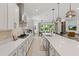 Stylish kitchen boasting white cabinetry, quartz countertops, and a seamless flow into the dining and living areas at 14189 Larkspur Lake Dr, Winter Garden, FL 34787