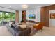 Comfortable living room features stylish wood paneling, a modern entertainment center, plush seating, and view to outside at 14189 Larkspur Lake Dr, Winter Garden, FL 34787