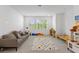 Bright playroom features neutral tones, a plush gray couch and a colorful polka dot rug for a cheerful design at 14189 Larkspur Lake Dr, Winter Garden, FL 34787