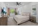 Bright and airy main bedroom featuring a ceiling fan, large windows, and a cozy seating area at 14189 Larkspur Lake Dr, Winter Garden, FL 34787